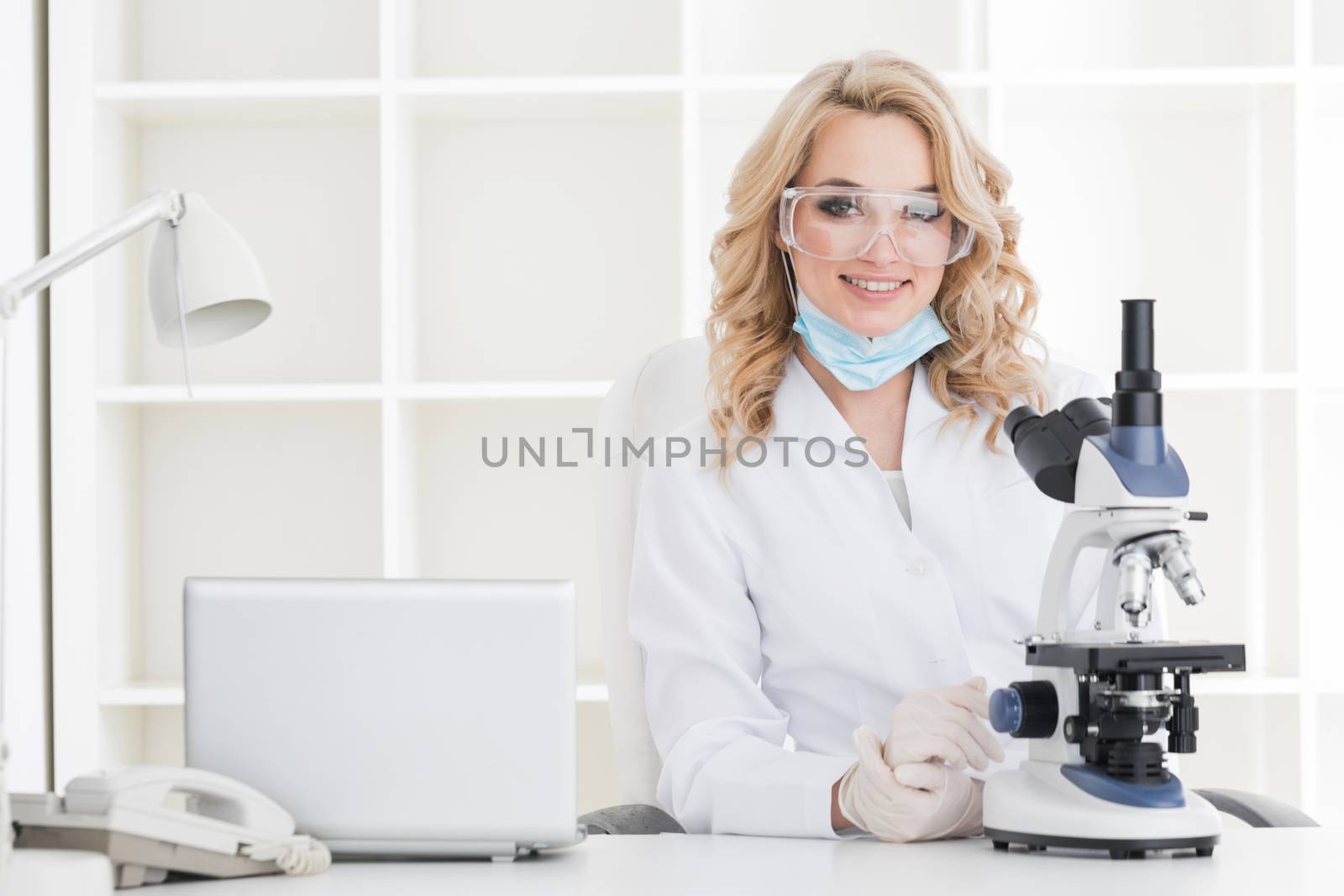 Portrait of a female researcher or medical doctor doing research using microscope in a laboratory