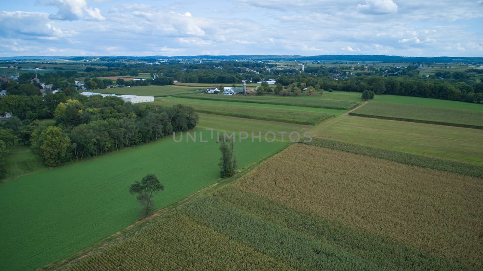 Aerial view of Amish countryside with barns and silos on a sunny summer day