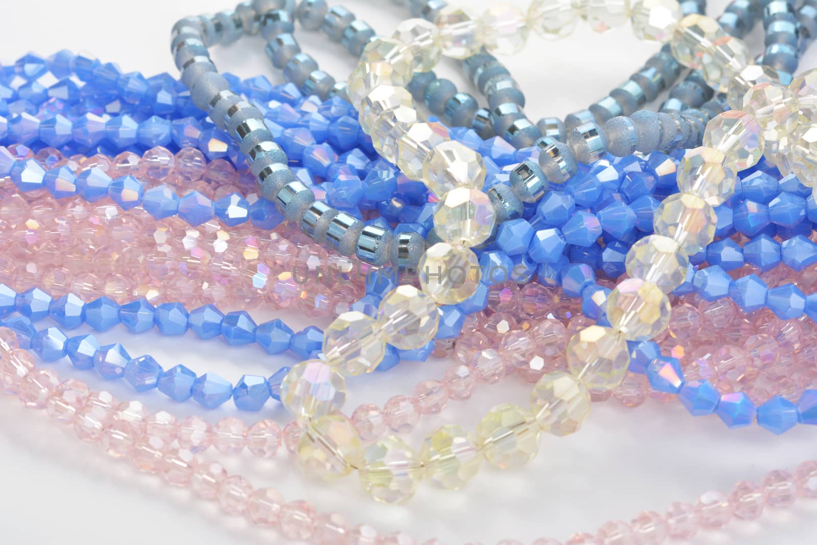 Color faceted glass sparkle beads. Materials for creative work on white background. by polyats