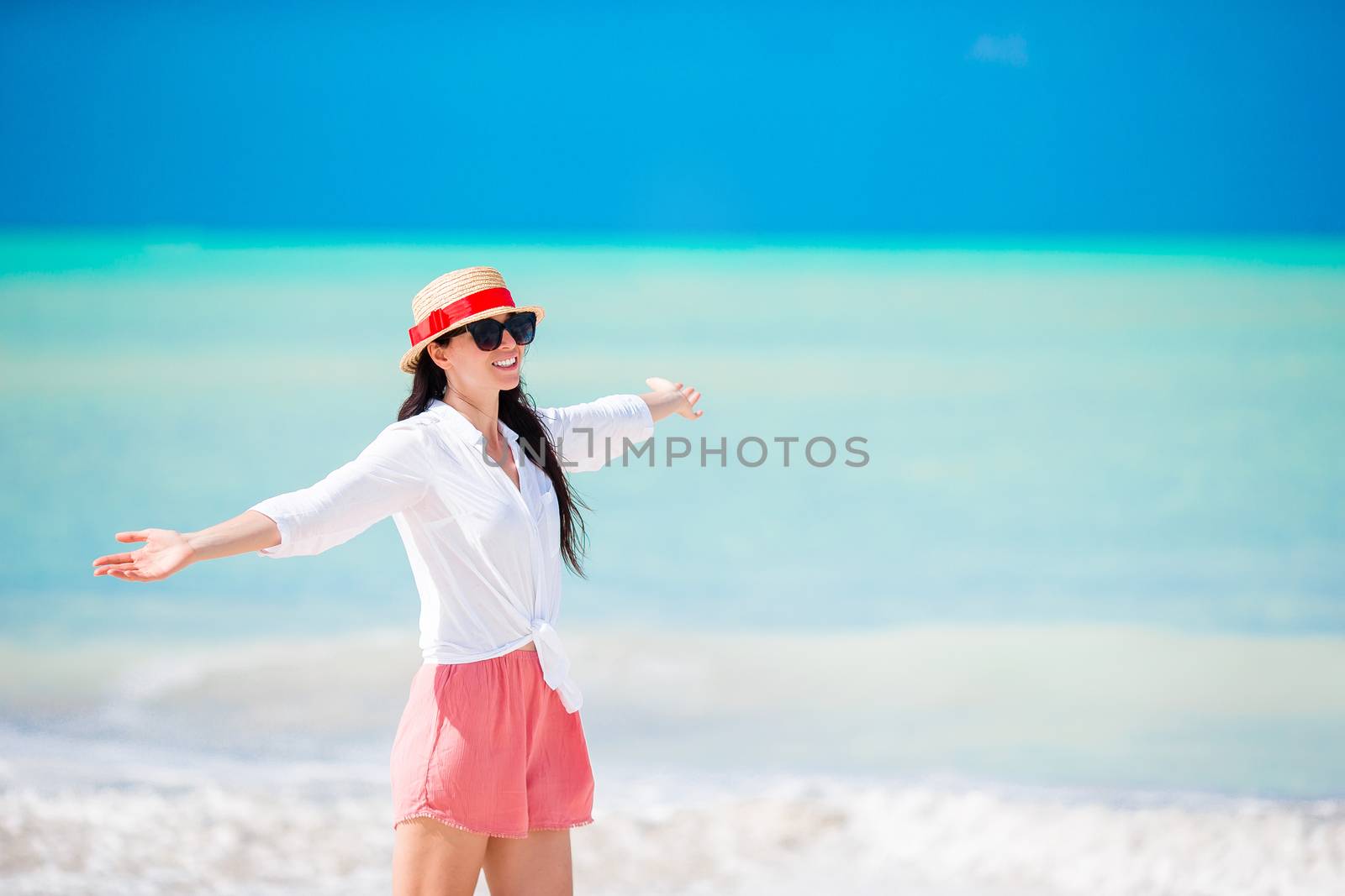 Young beautiful woman on white sand tropical beach. Caucasian girl with hat background the sea by travnikovstudio