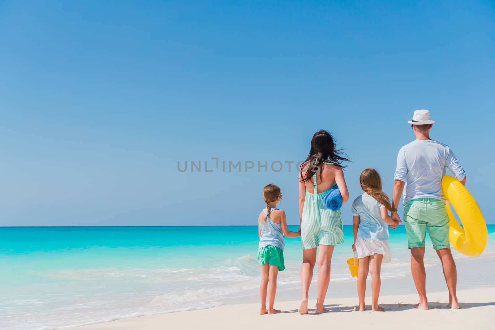 Happy beautiful family on white beach having fun by travnikovstudio