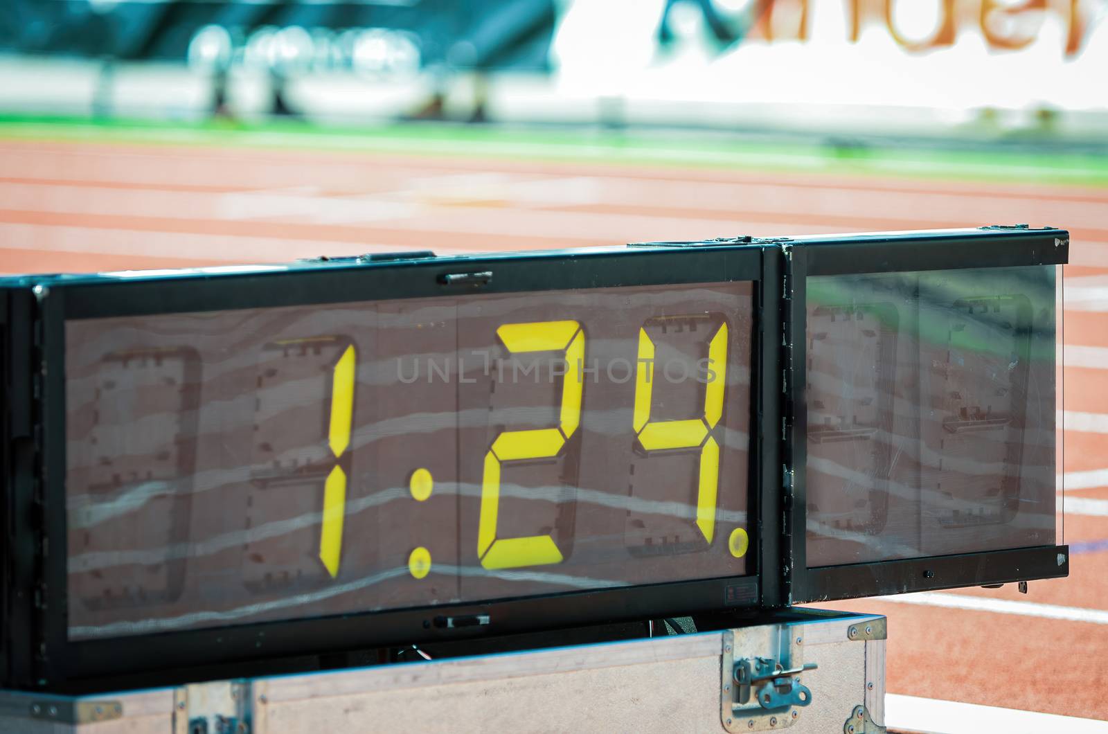 Digital sport chronometer in sport event next to athletic stadium tracks