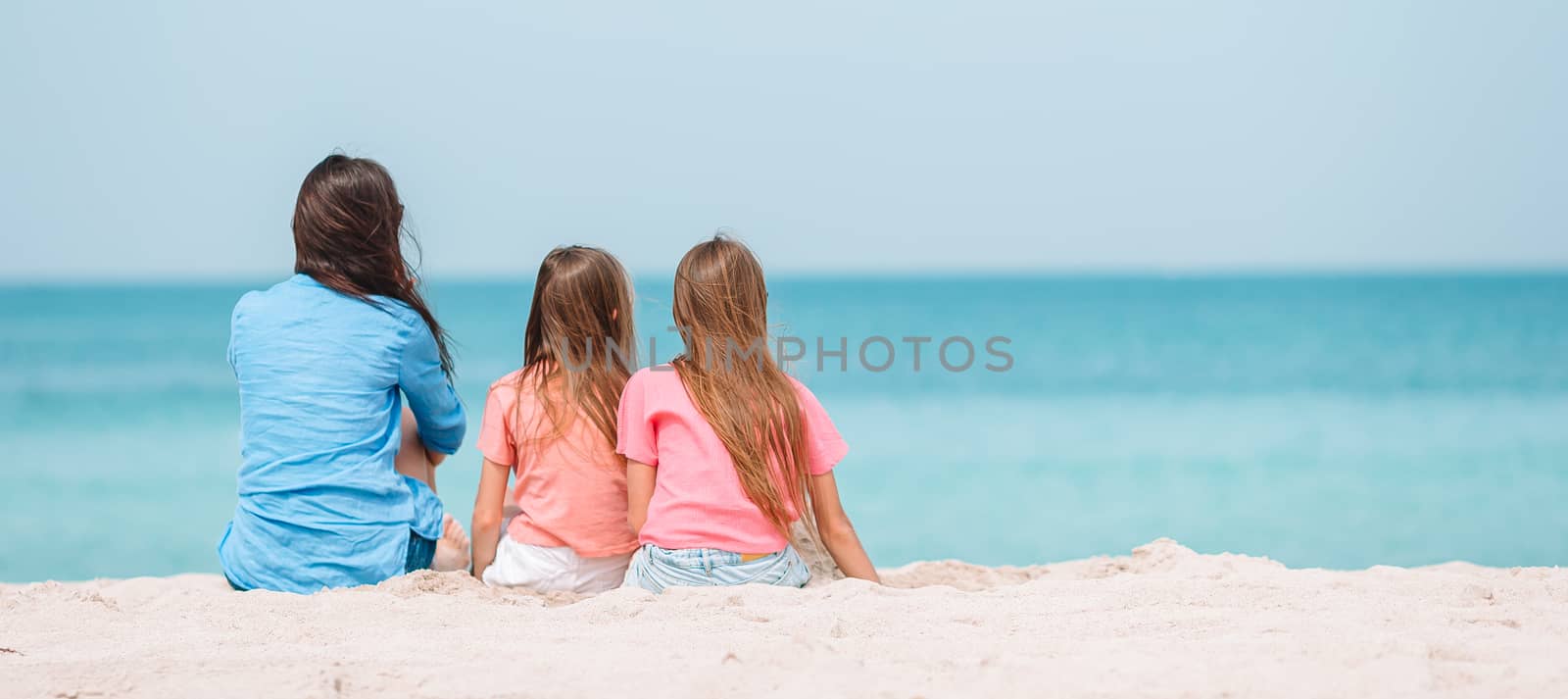 Adorable little girls and young mother on tropical white beach by travnikovstudio