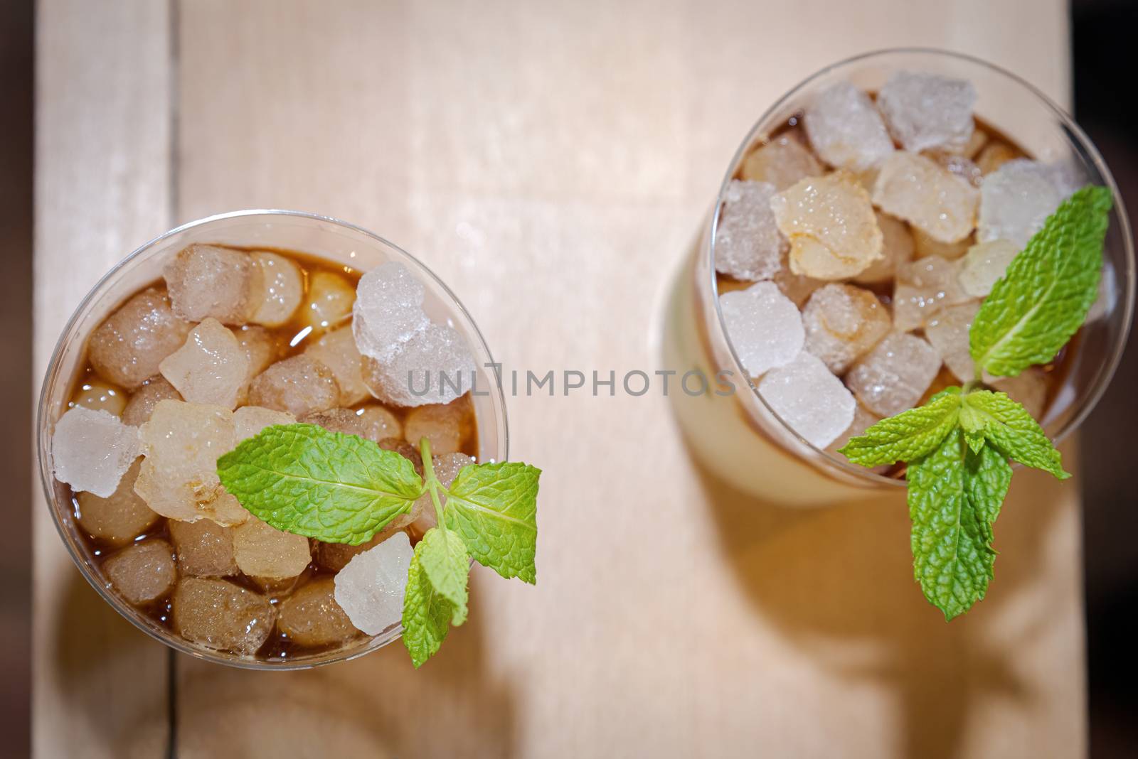 two glasses of mojito with ssu ices seen zenital flat on wooden board