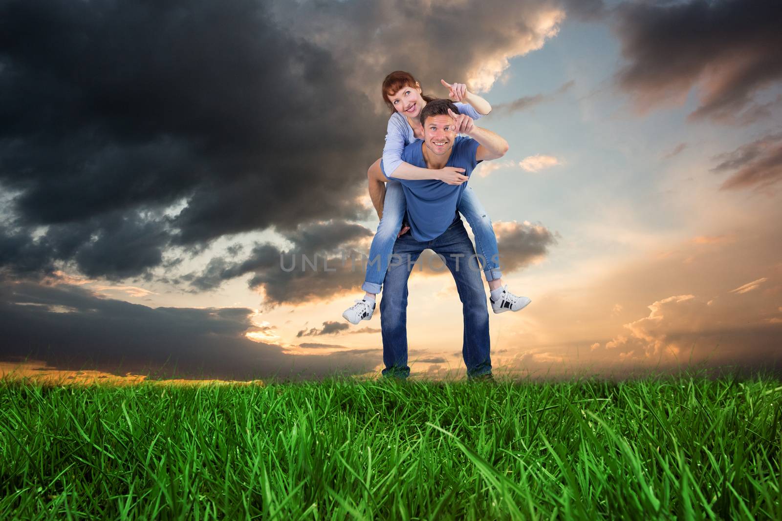 Man giving girl a piggy back against blue and orange sky with clouds