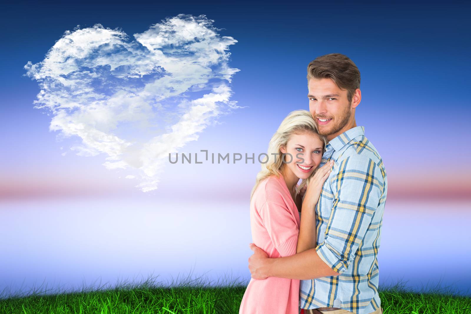 Attractive couple embracing and smiling at camera against cloud heart