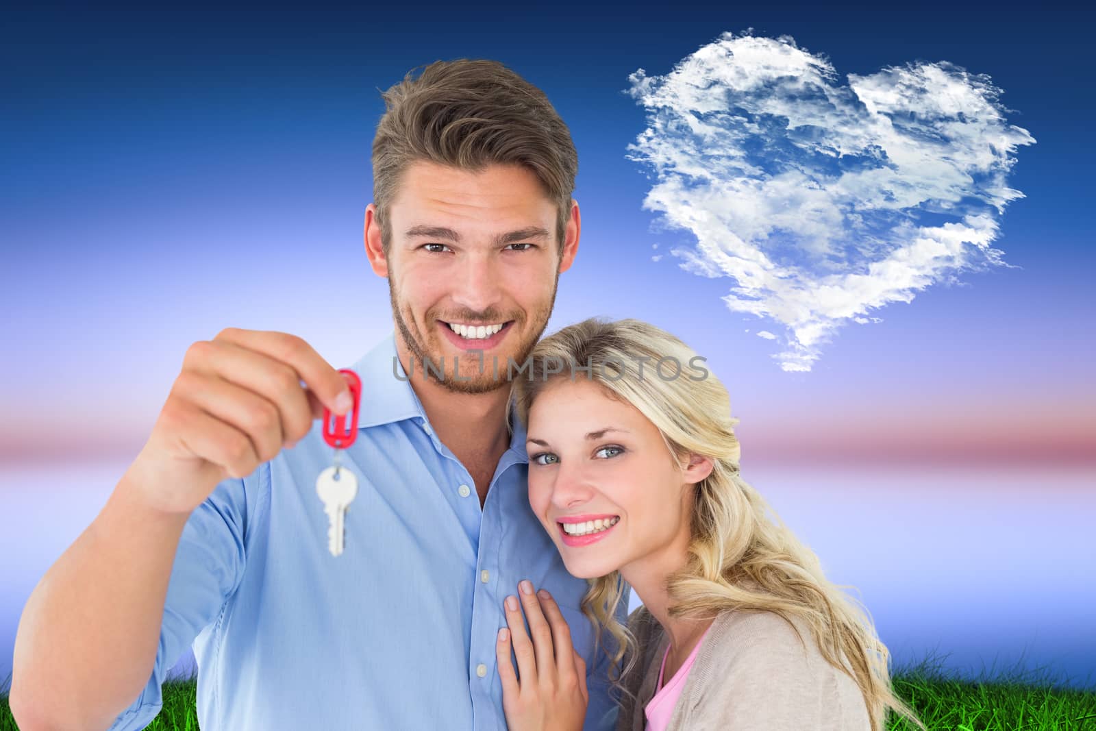 Attractive young couple showing new house key against cloud heart