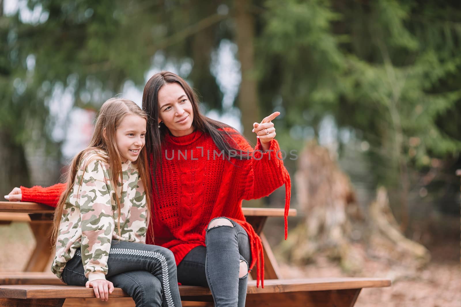 Mother and daughter playing with dog outdoors by travnikovstudio