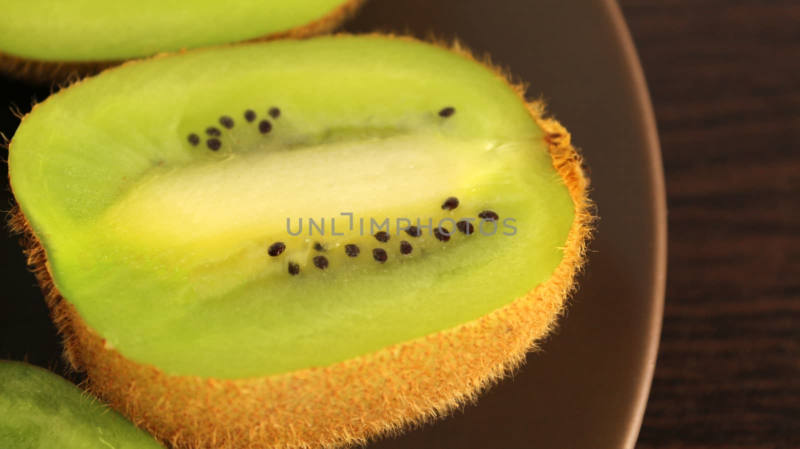sliced kiwi on a plate, on a dark background, macro