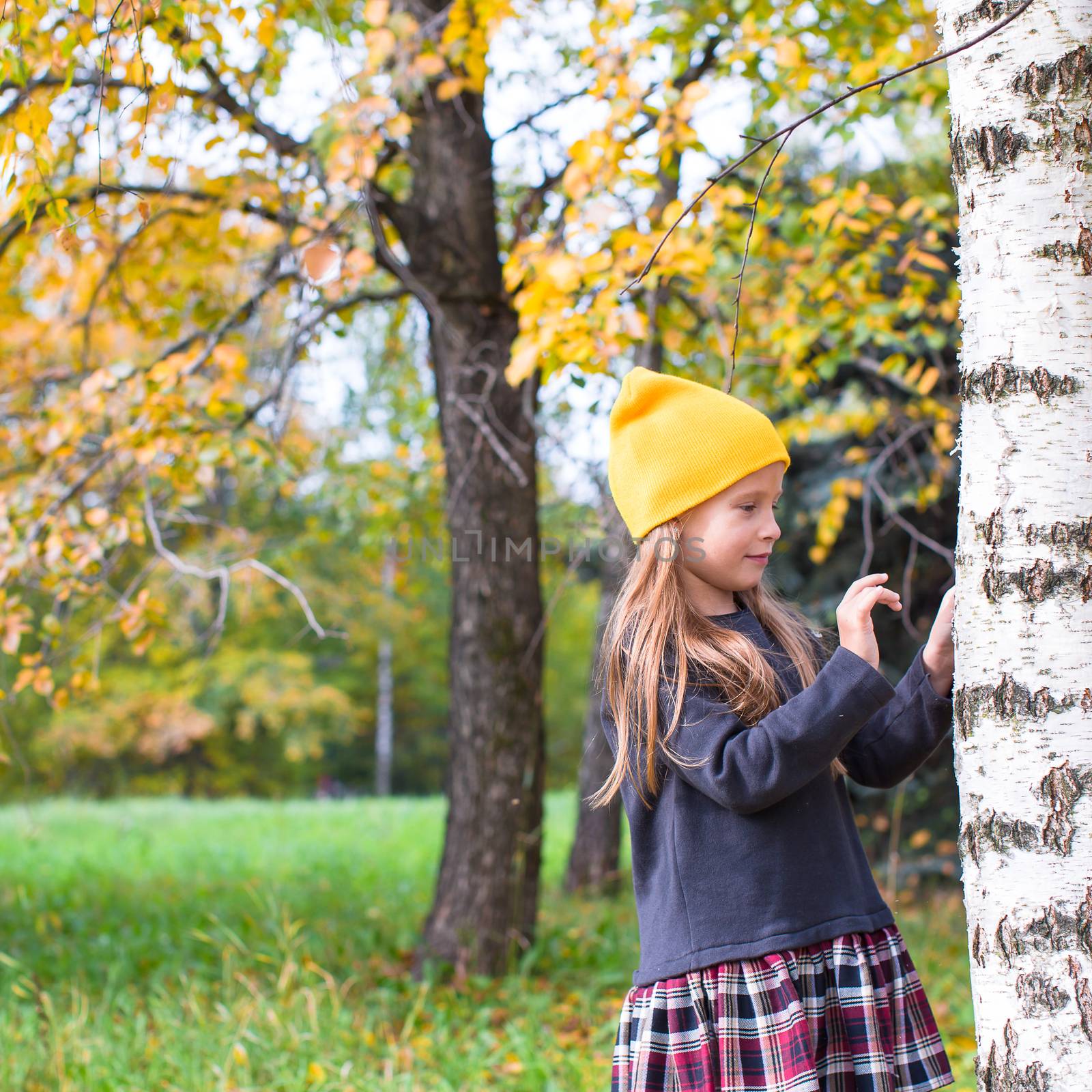 Little happy girl in autumn park outdoors by travnikovstudio