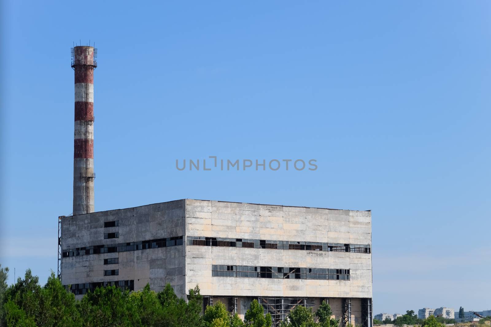 An old Soviet factory with a pipe. Abandoned Soviet industry.