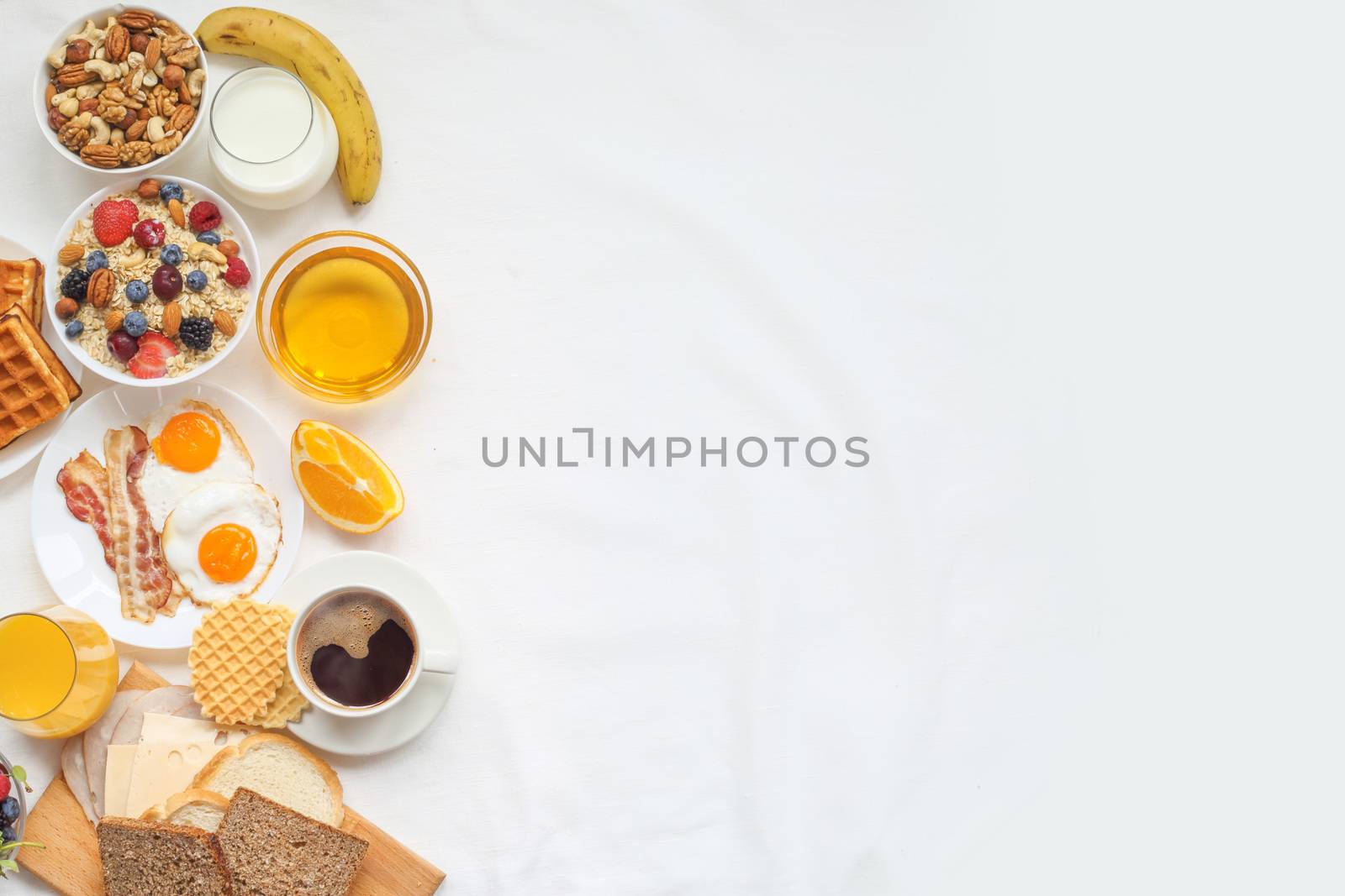 Healthy breakfast with muesli, fruits, berries, nuts, coffee, eggs, honey, oat grains and other on white background. Flat lay, top view, copy space for text, frame