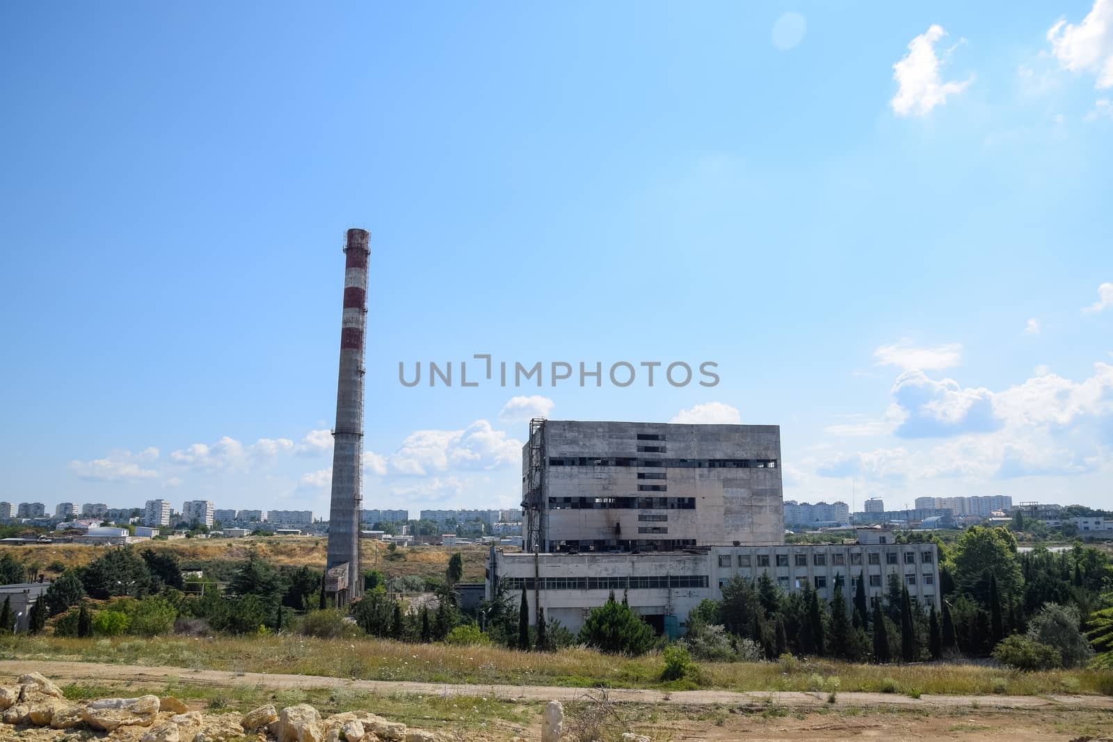 old Soviet factory with a pipe. Abandoned Soviet industry. by fedoseevaolga