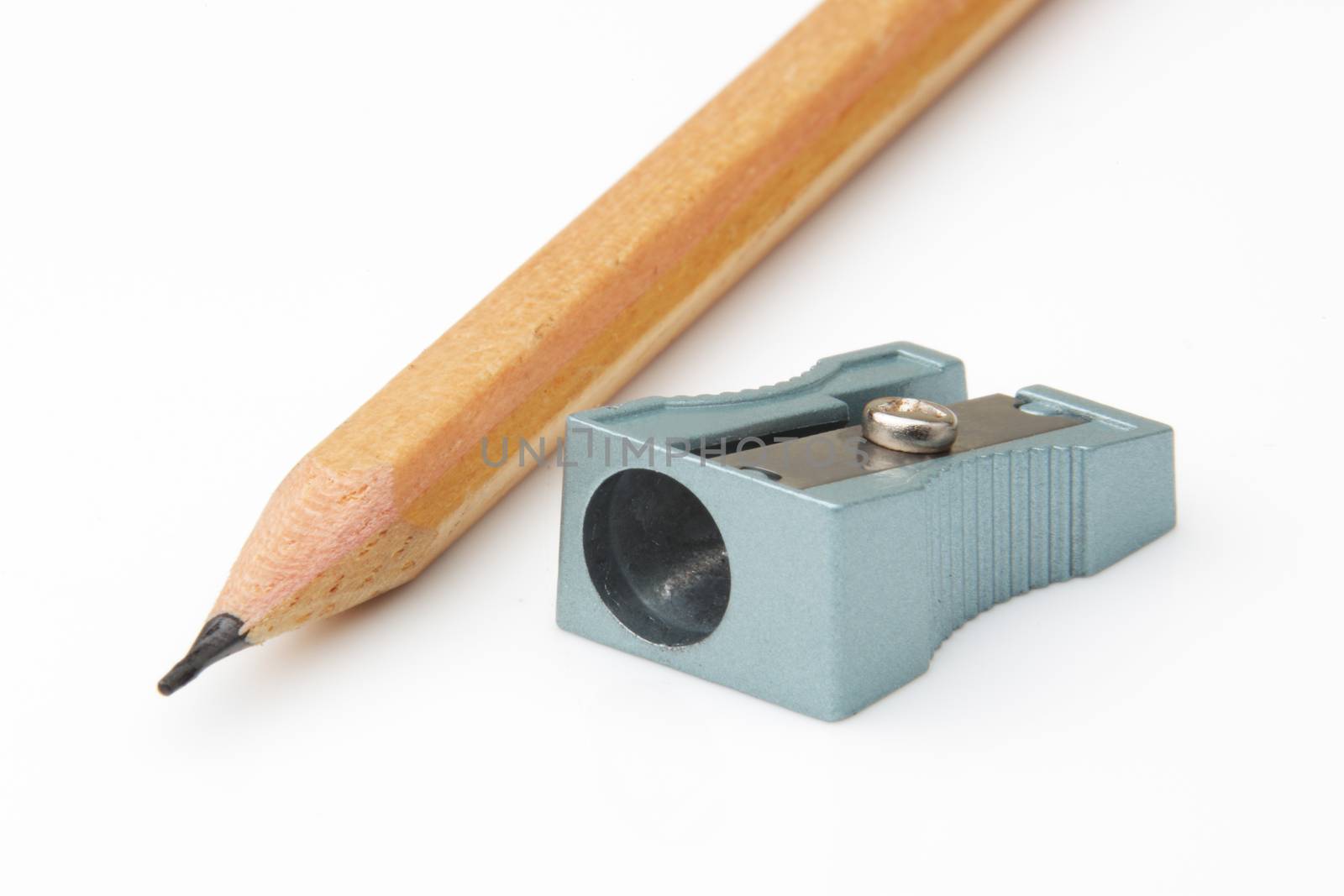 A brown pencil and pencil sharpener angled on a white background