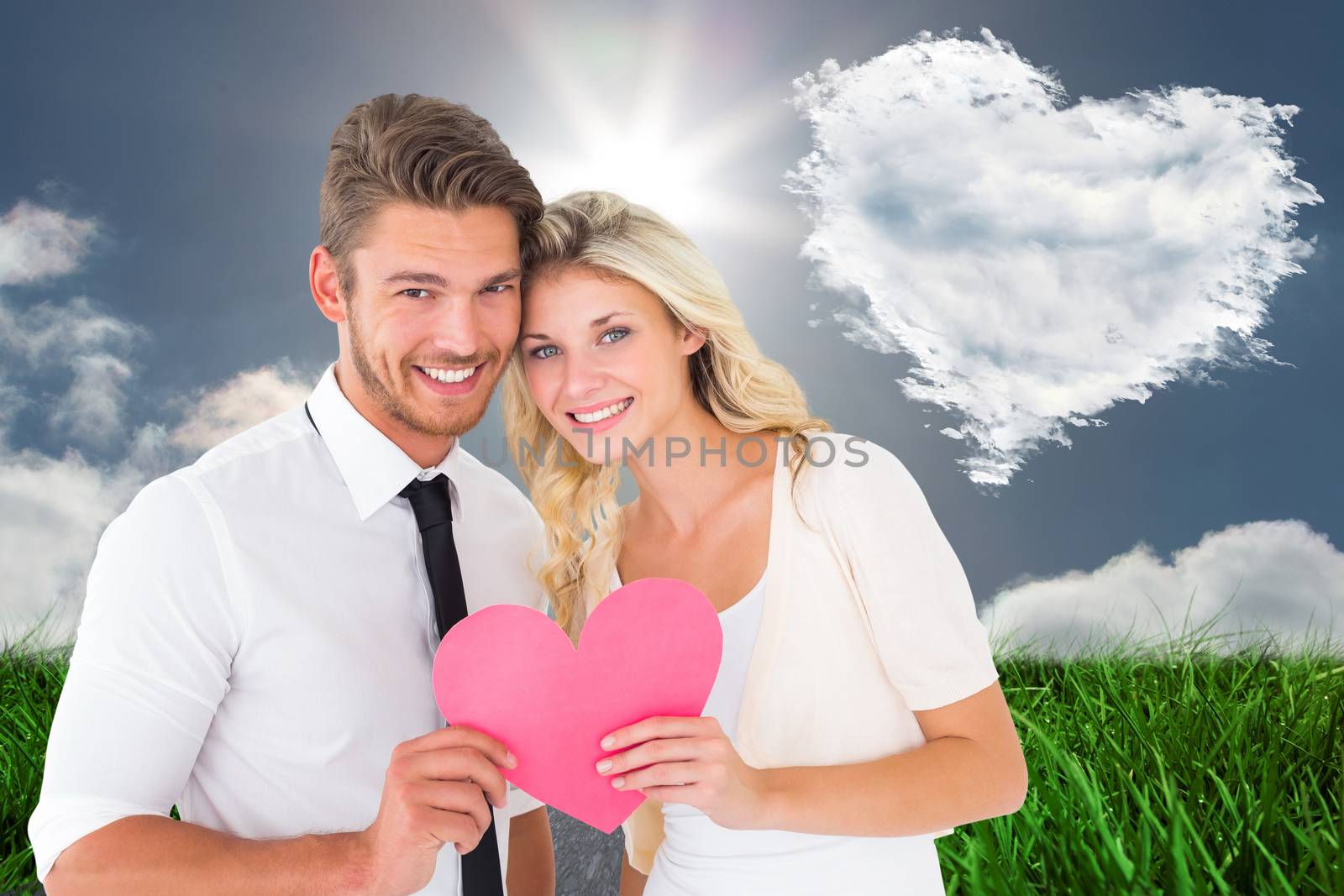 Attractive young couple holding pink heart against cloud heart