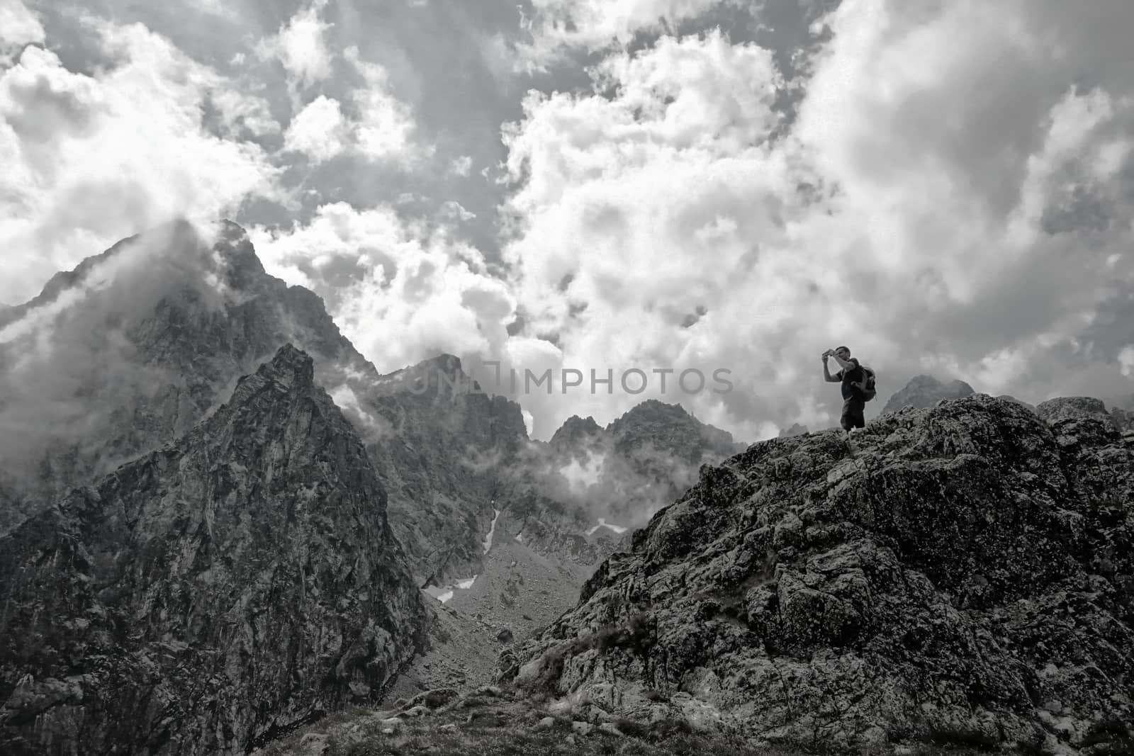 Man with hiking equipment walking in High Tatra mountain in Slovakia. Majestic View on the Lomnicky Stit in the background by aijaphoto