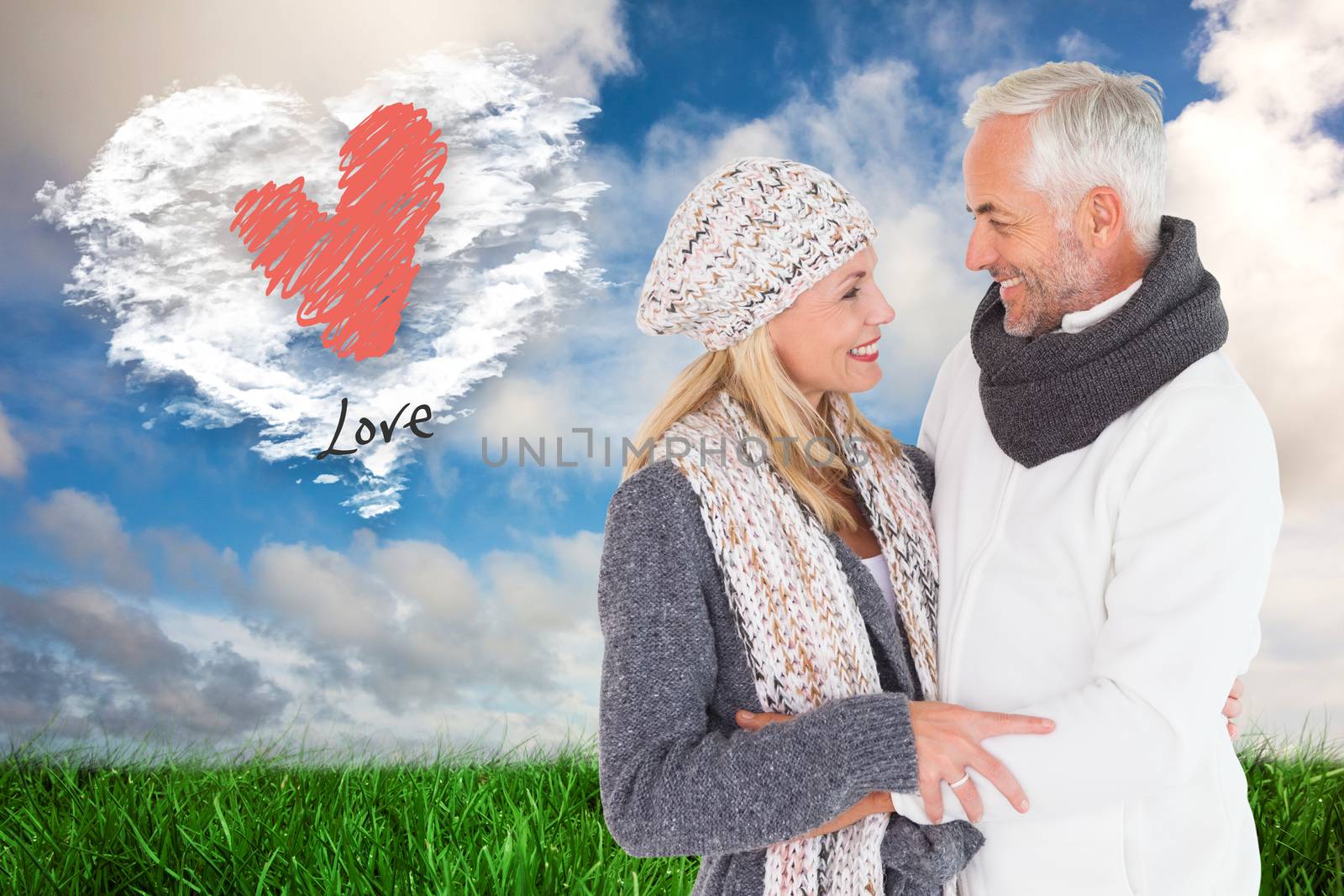Happy couple in winter fashion embracing against cloud heart
