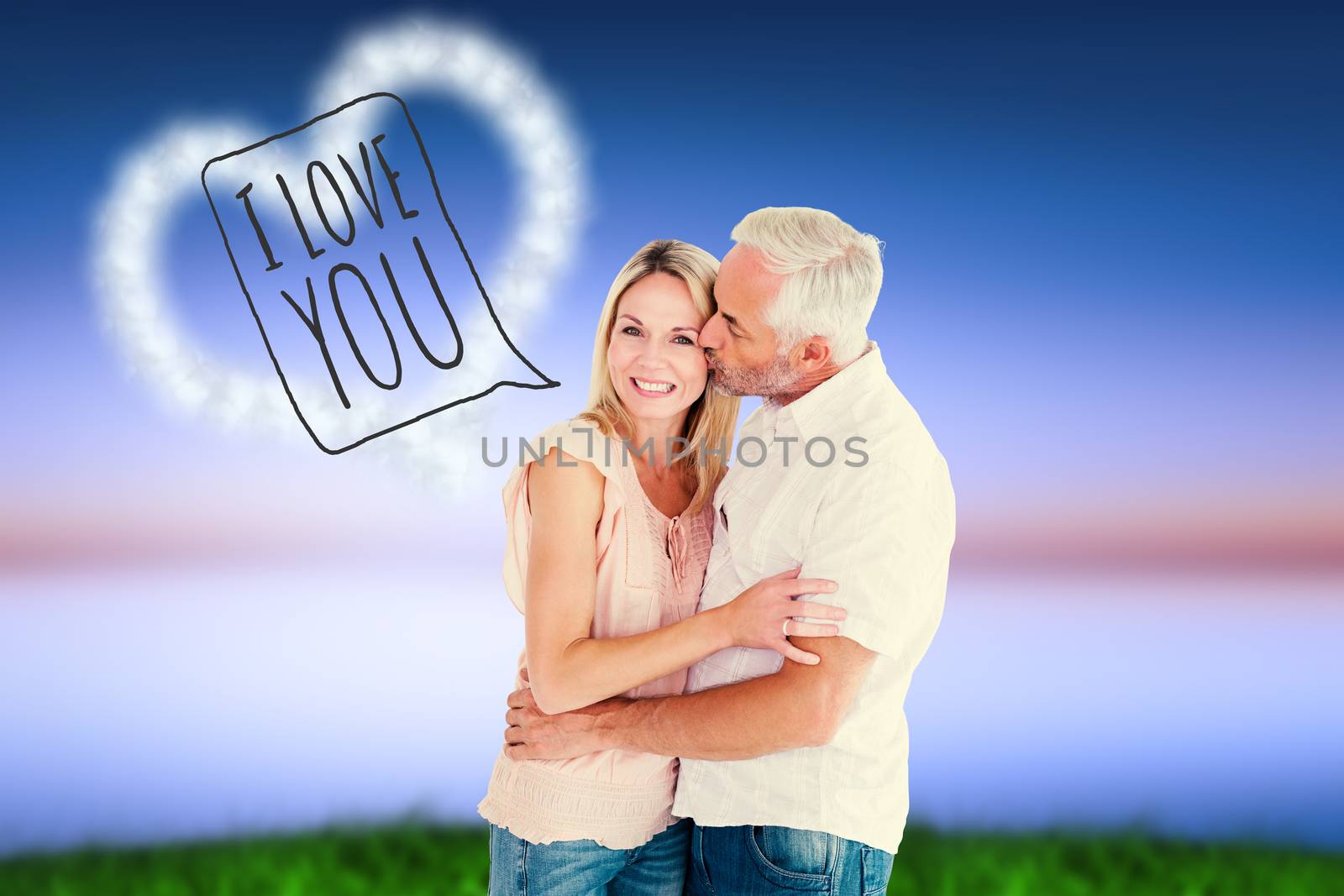 Affectionate man kissing his wife on the cheek against green grass under blue and purple sky