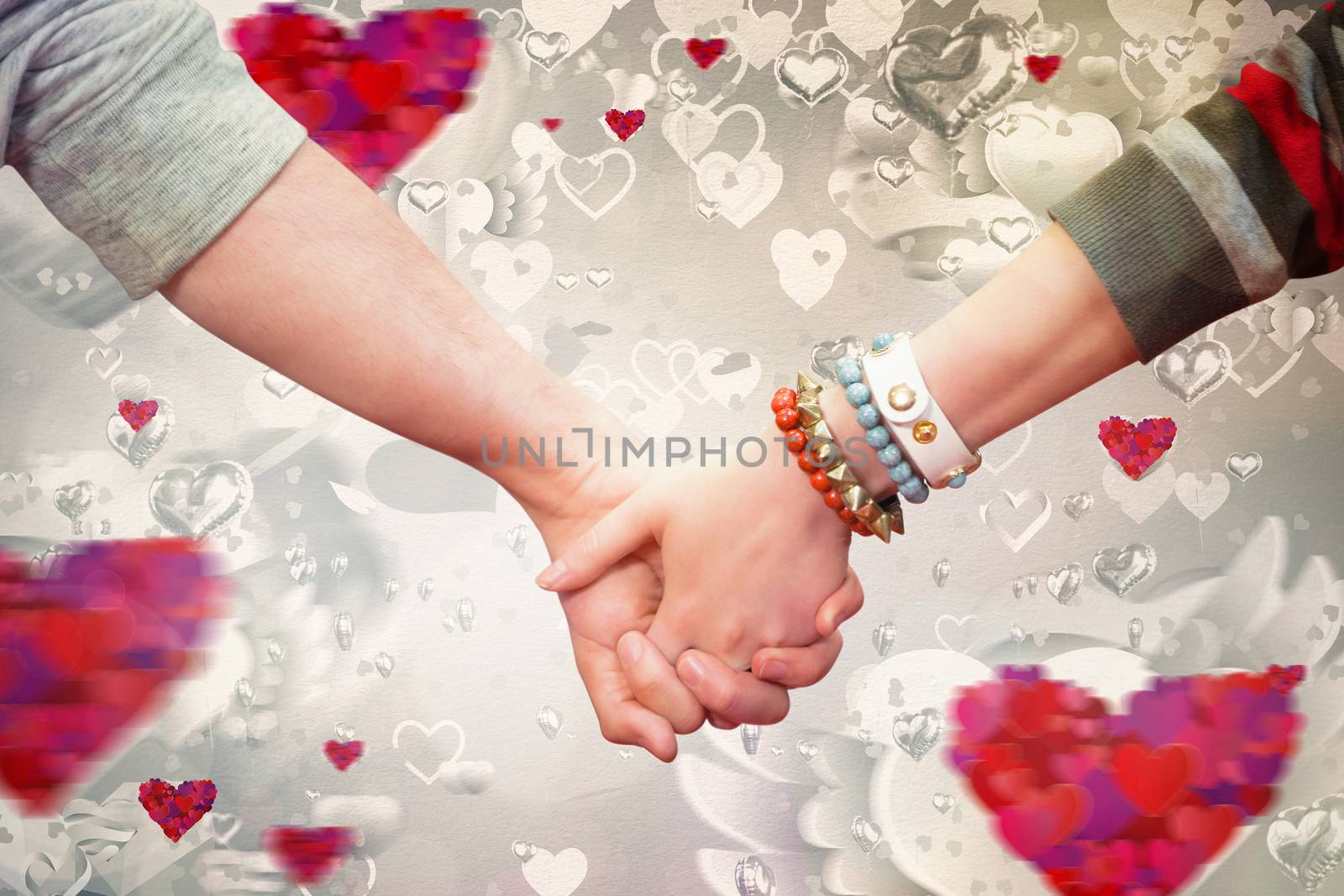 Students holding hands against love heart pattern