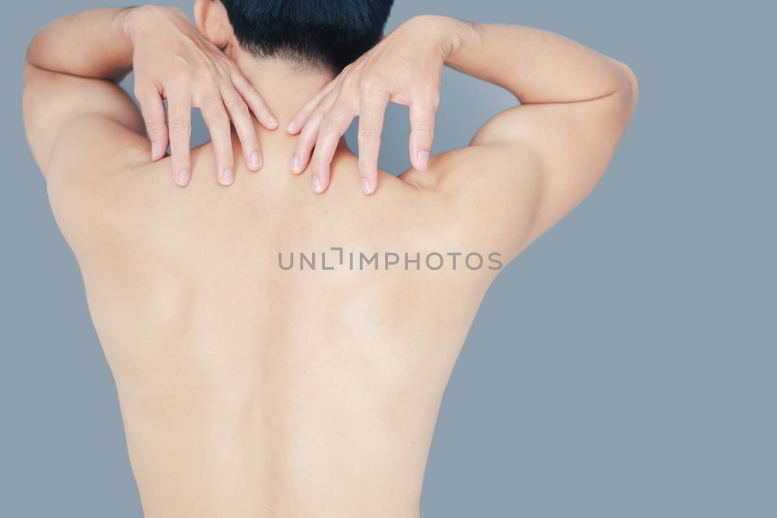 Closeup man hand holding shoulder with pain on blue background, health care and medical concept