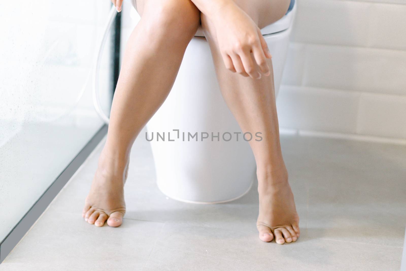 Closeup woman sitting on toilet in the morning, selective focus