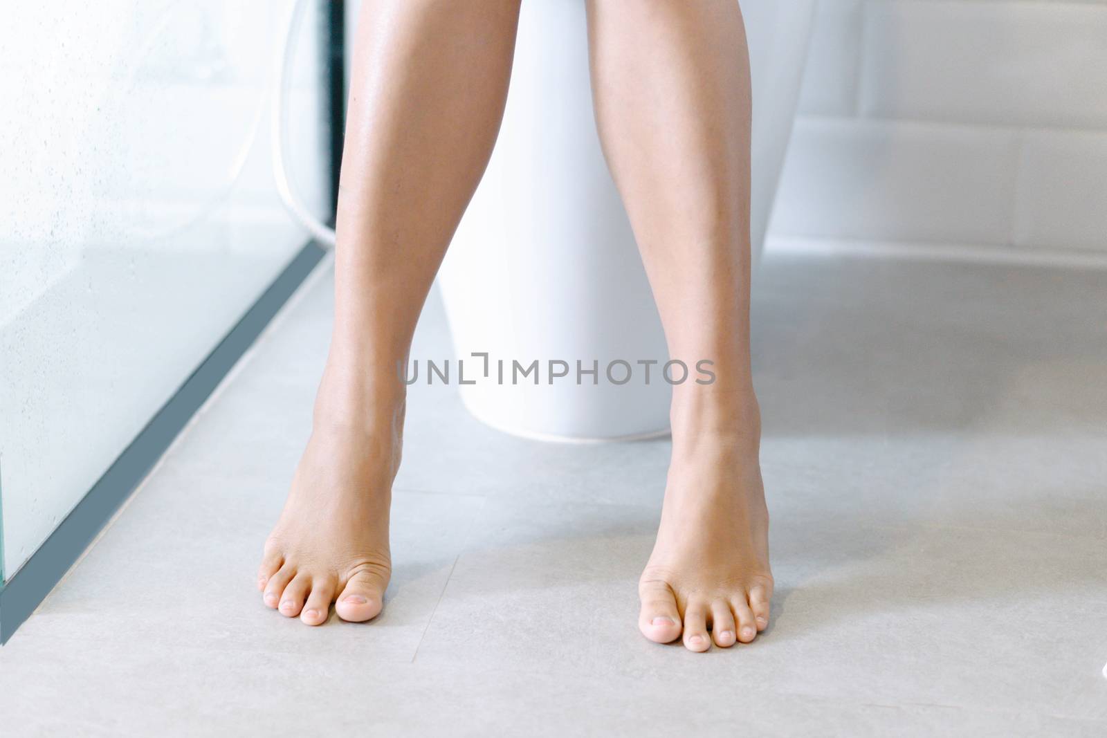 Closeup woman sitting on toilet in the morning, selective focus