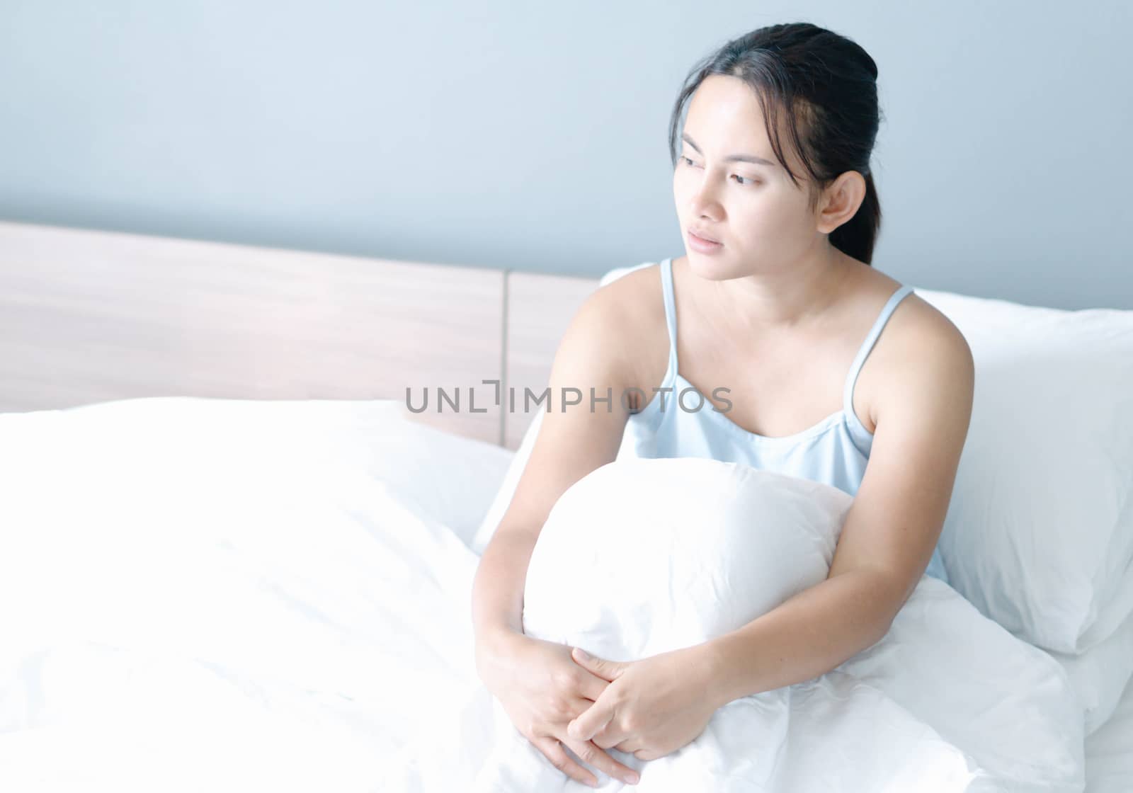 Closeup woman sitting on bed in the bedroom with thinking or dep by pt.pongsak@gmail.com