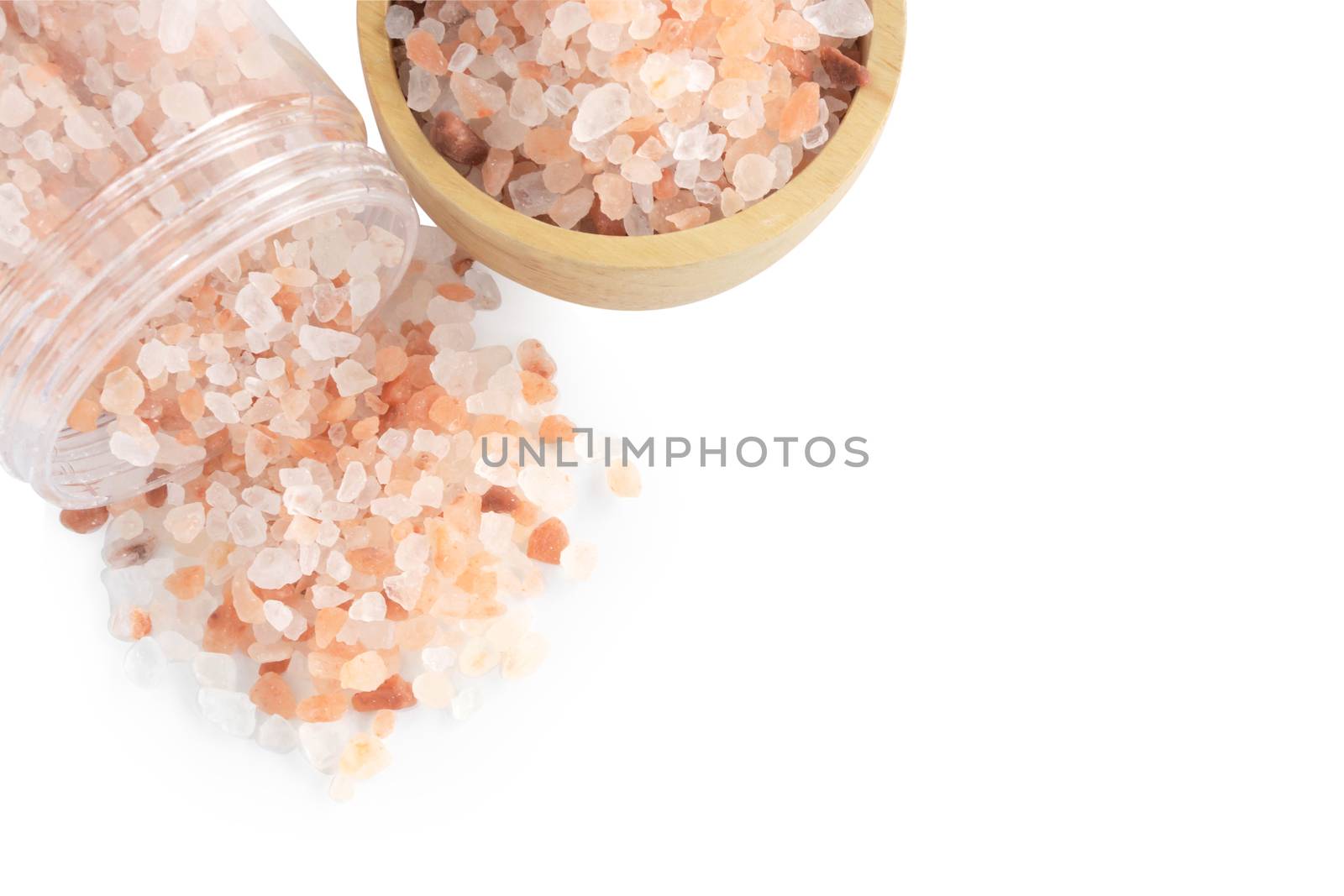 Himalayan pink salt in plastic bottle and wooden bowl isoleted on white background, healthy concept