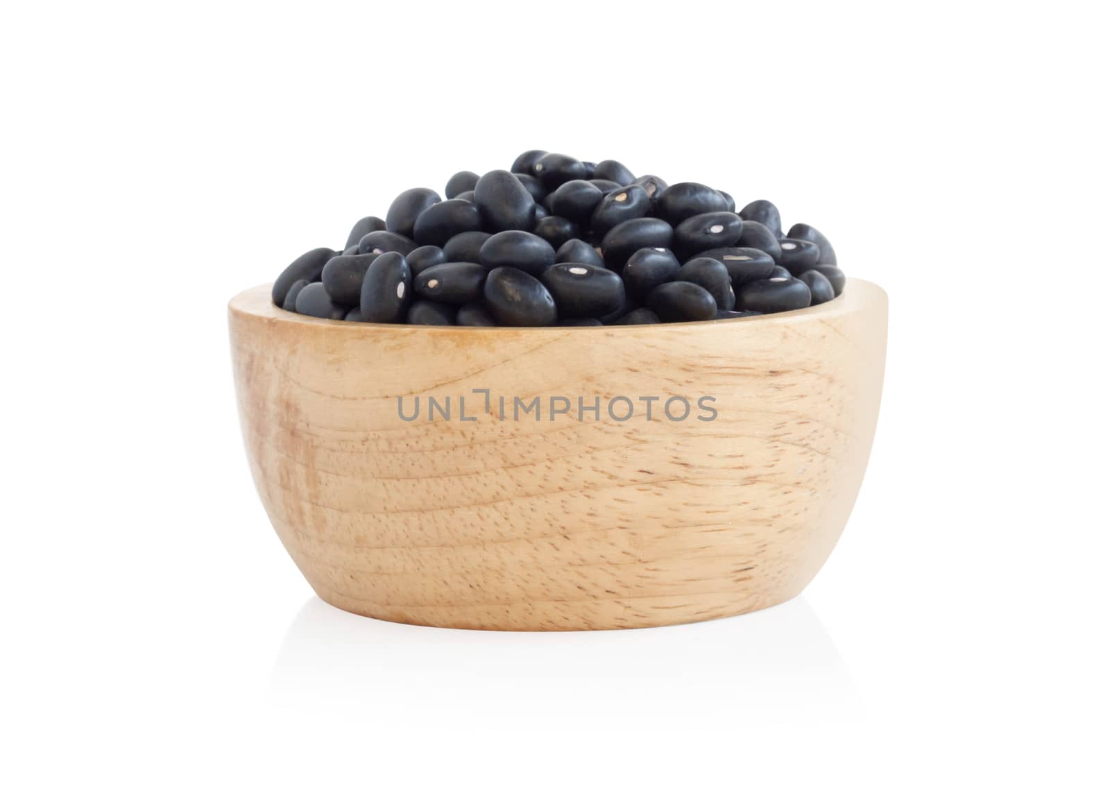 Closeup black beans seeds in wooden bowl on white background, healthy food concept