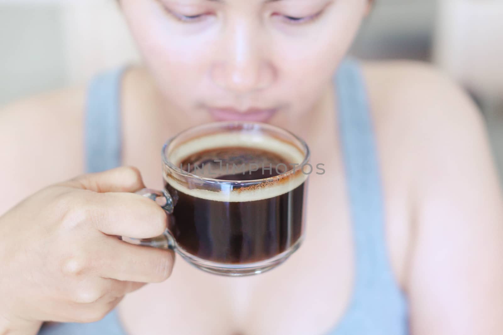 Closeup woman hand holding glass of hot americano coffee, select by pt.pongsak@gmail.com