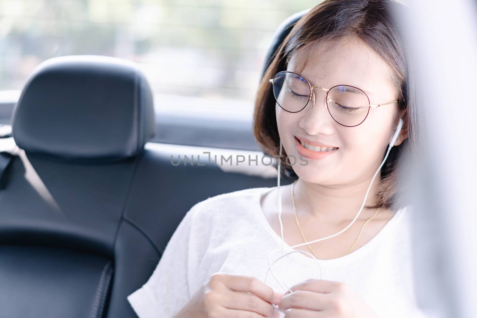 Closeup asian woman using digital tablet in a car with happy face