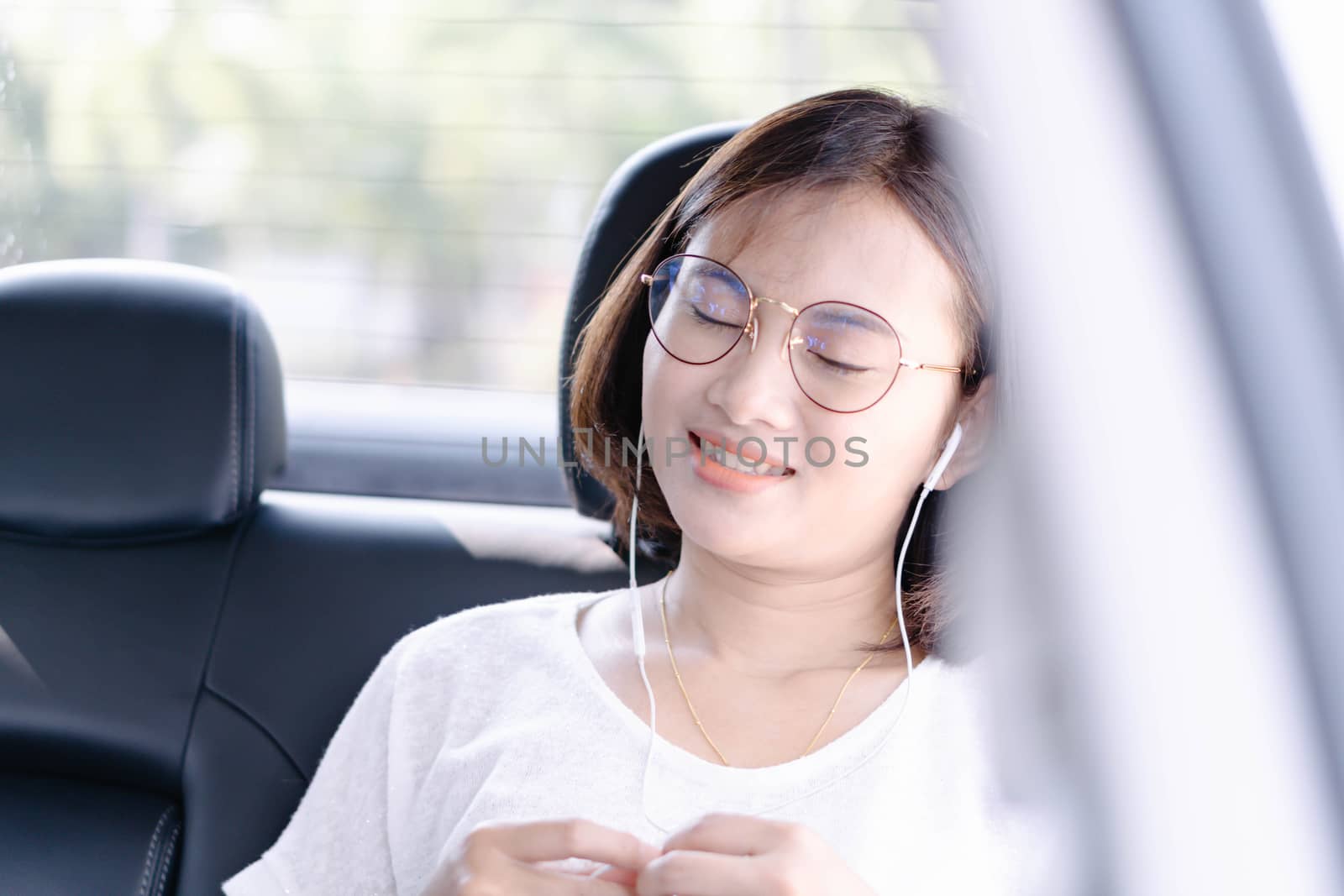 Closeup asian woman using digital tablet in a car with happy face