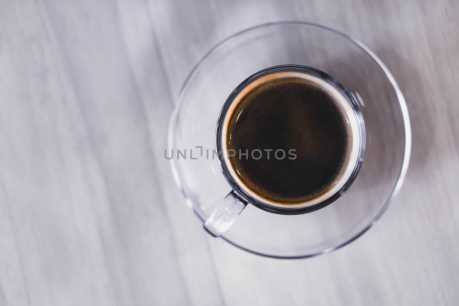 Closeup glass of hot americano coffee on wood table, selective focus, vintage tone