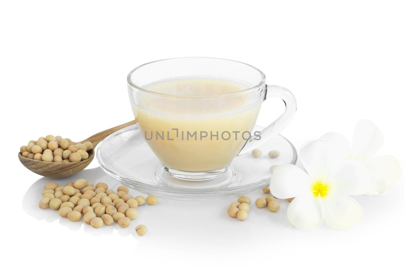Soy milk in glass with soy beans in wooden spoon isolated on white background, health care concept