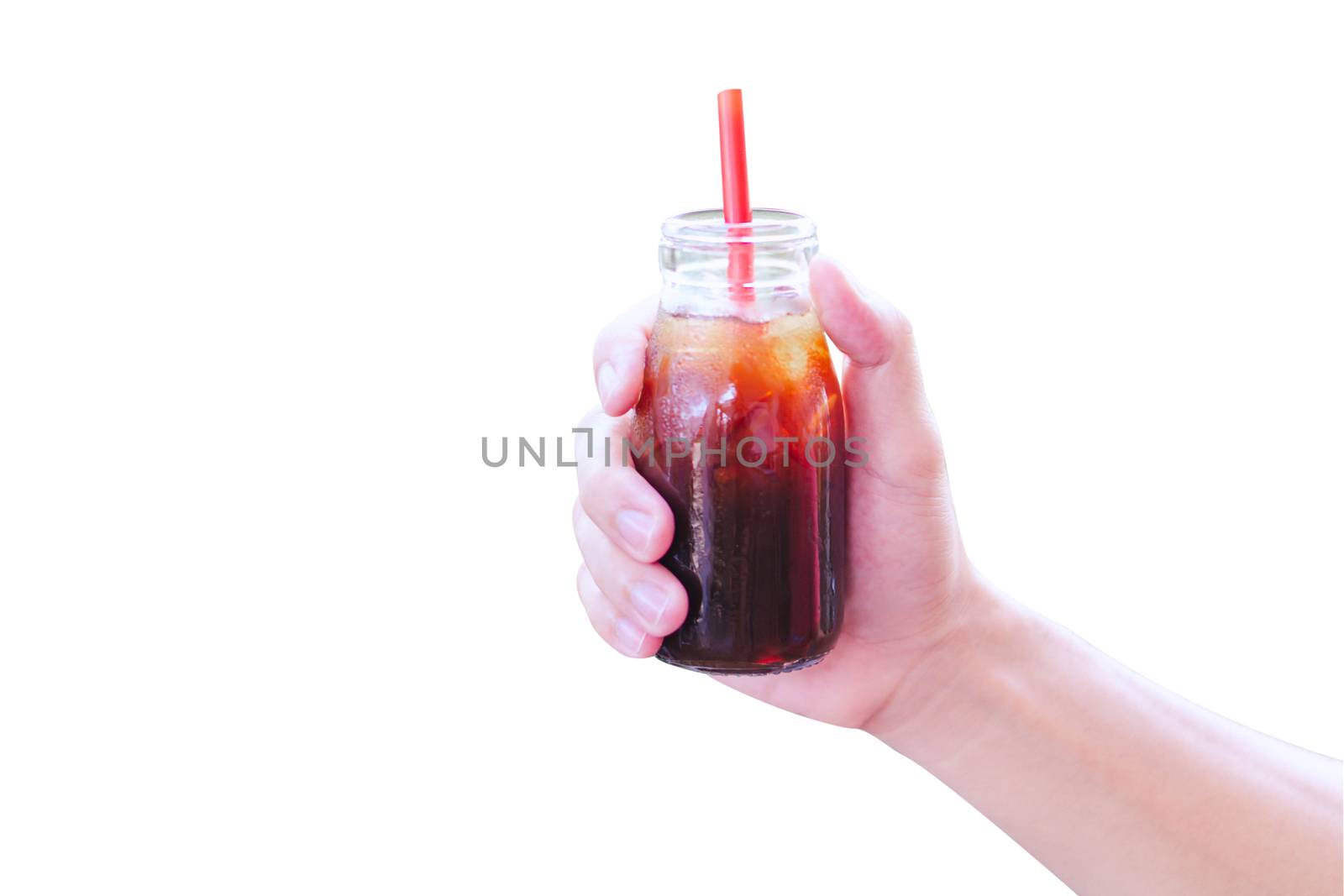 Close up hand holding bottle glass of americano coffee with green nature background, selective focus