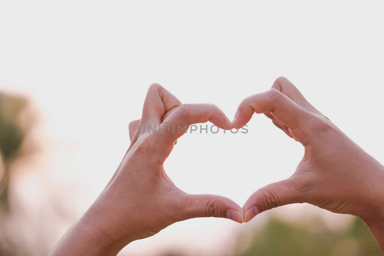 Closeup hand make heart shape with nature background, selective focus