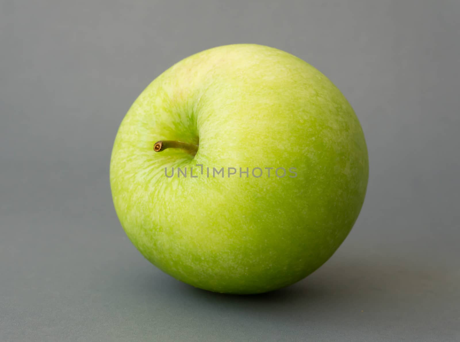 Closeup green apple on grey background, fruit for healthy diet concept