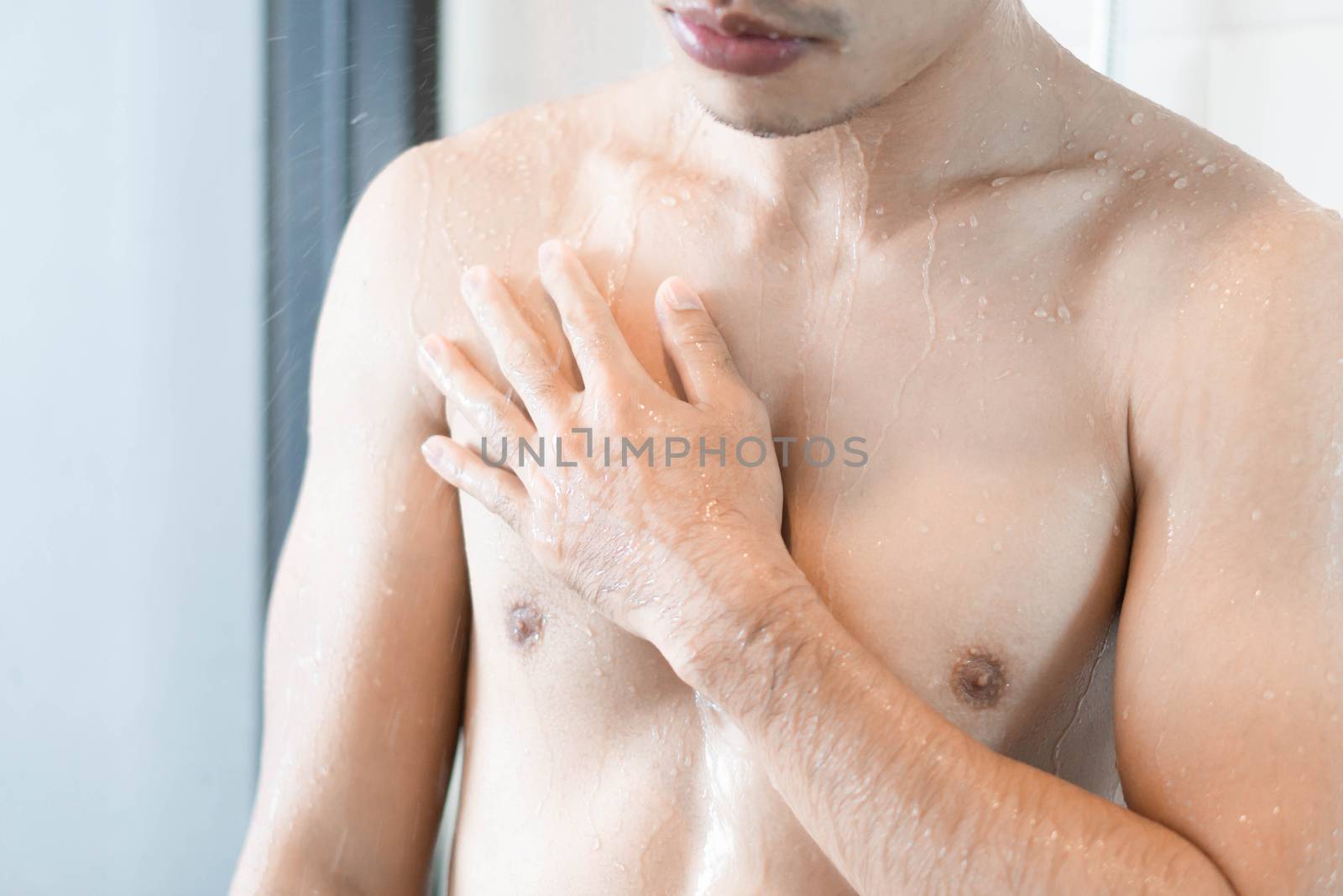 Closeup young man washing hair with with shampoo in the bathroom, vintage tone, selective focus