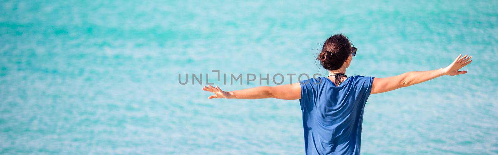 Young fashion woman in hat on the beach by travnikovstudio