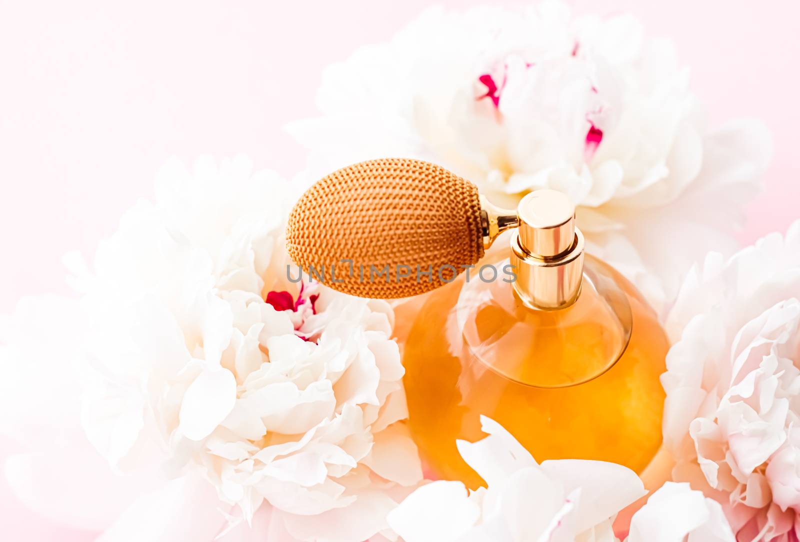 Chic fragrance bottle as citrus perfume product on background of peony flowers, parfum ad and beauty branding design