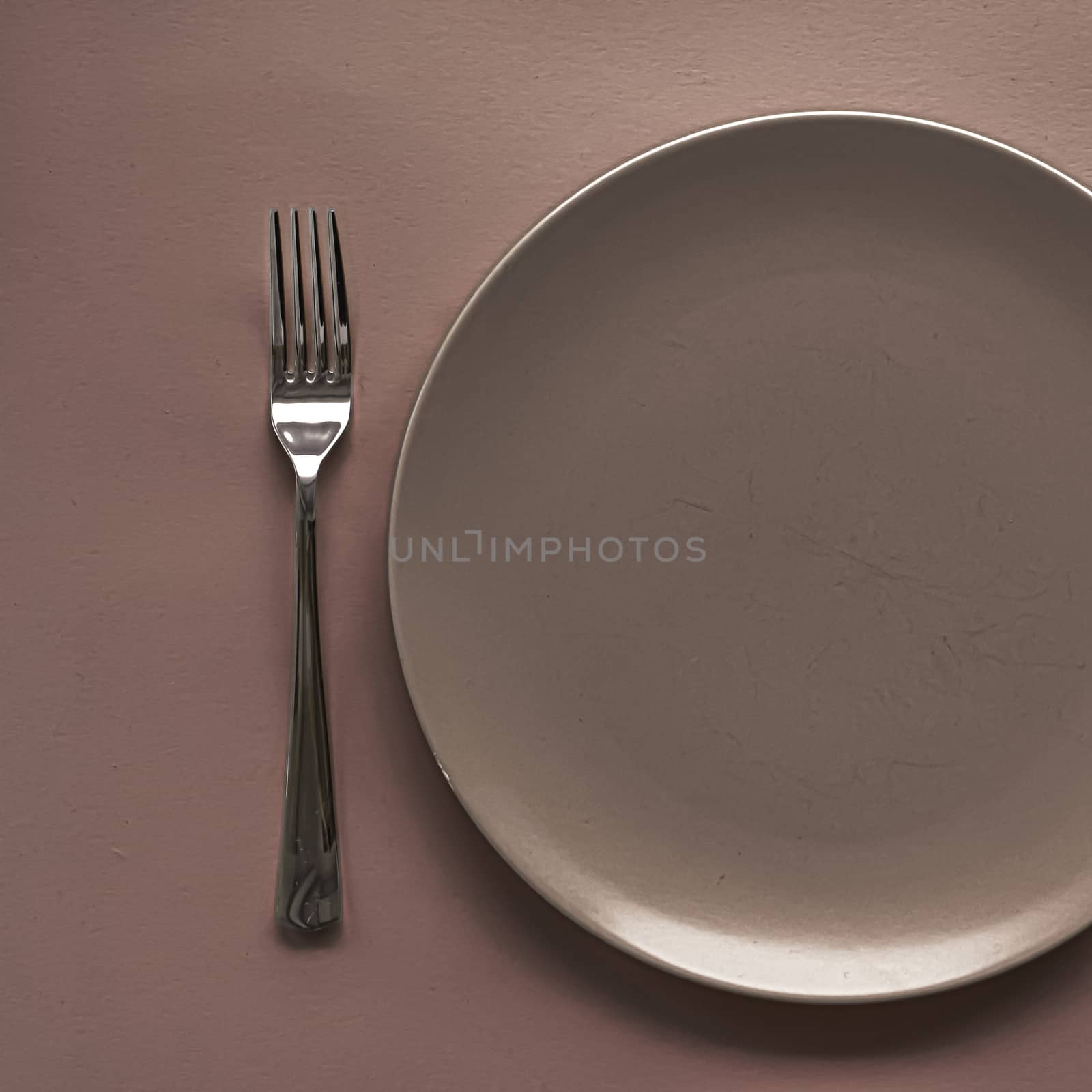 Empty plate and cutlery as mockup set on brown background, top tableware for chef table decor and menu branding by Anneleven