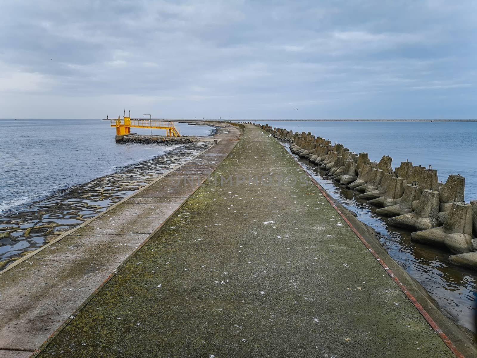 Concrete water pier in Swinoujscie with Baltic sea and breakwaters around