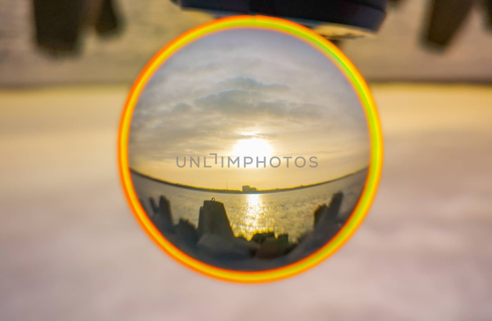 Sunset over baltic sea and coast of Swinoujscie city seen from breakwater in crystal glassball reflection by Wierzchu