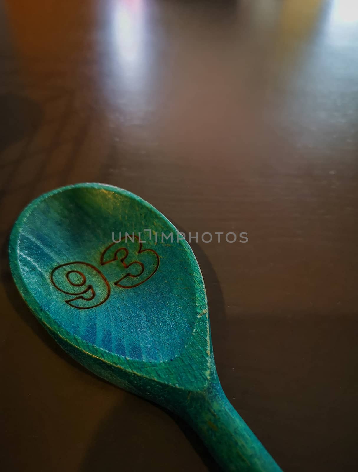 Number 93 engravered on green wooden spoon