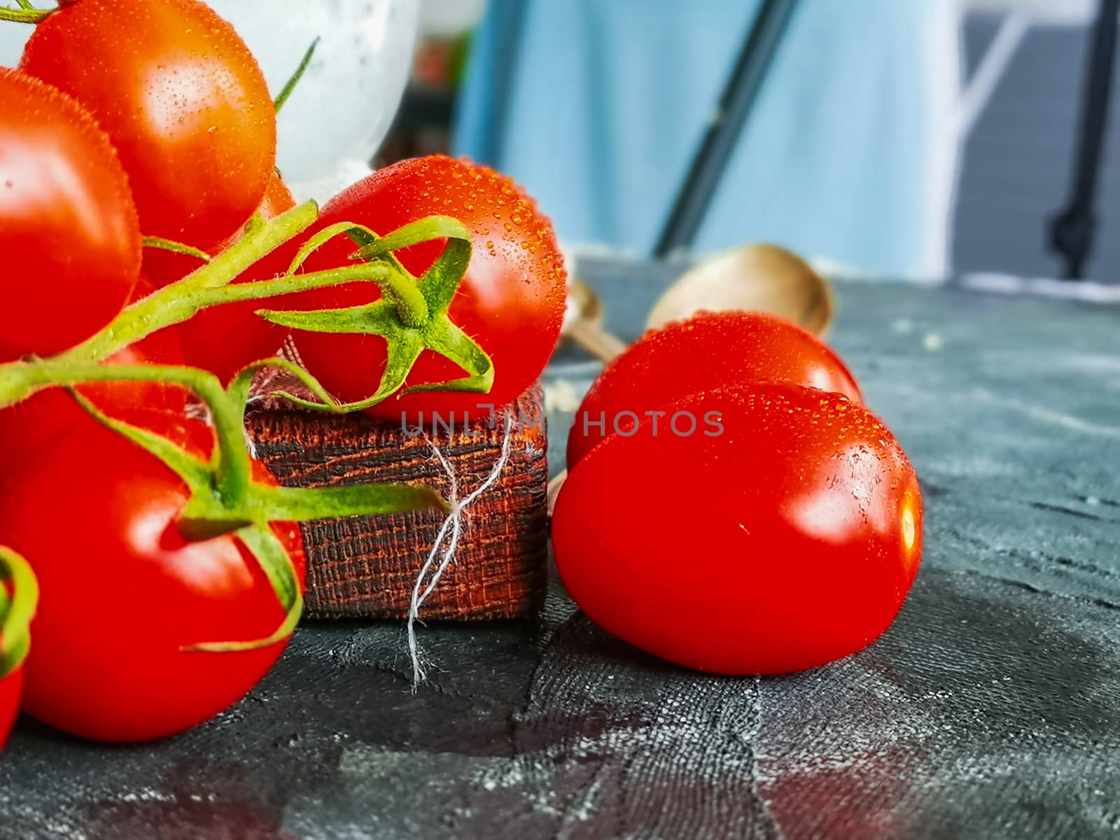 Small water drops on small cherry tomatoes on green branch by Wierzchu