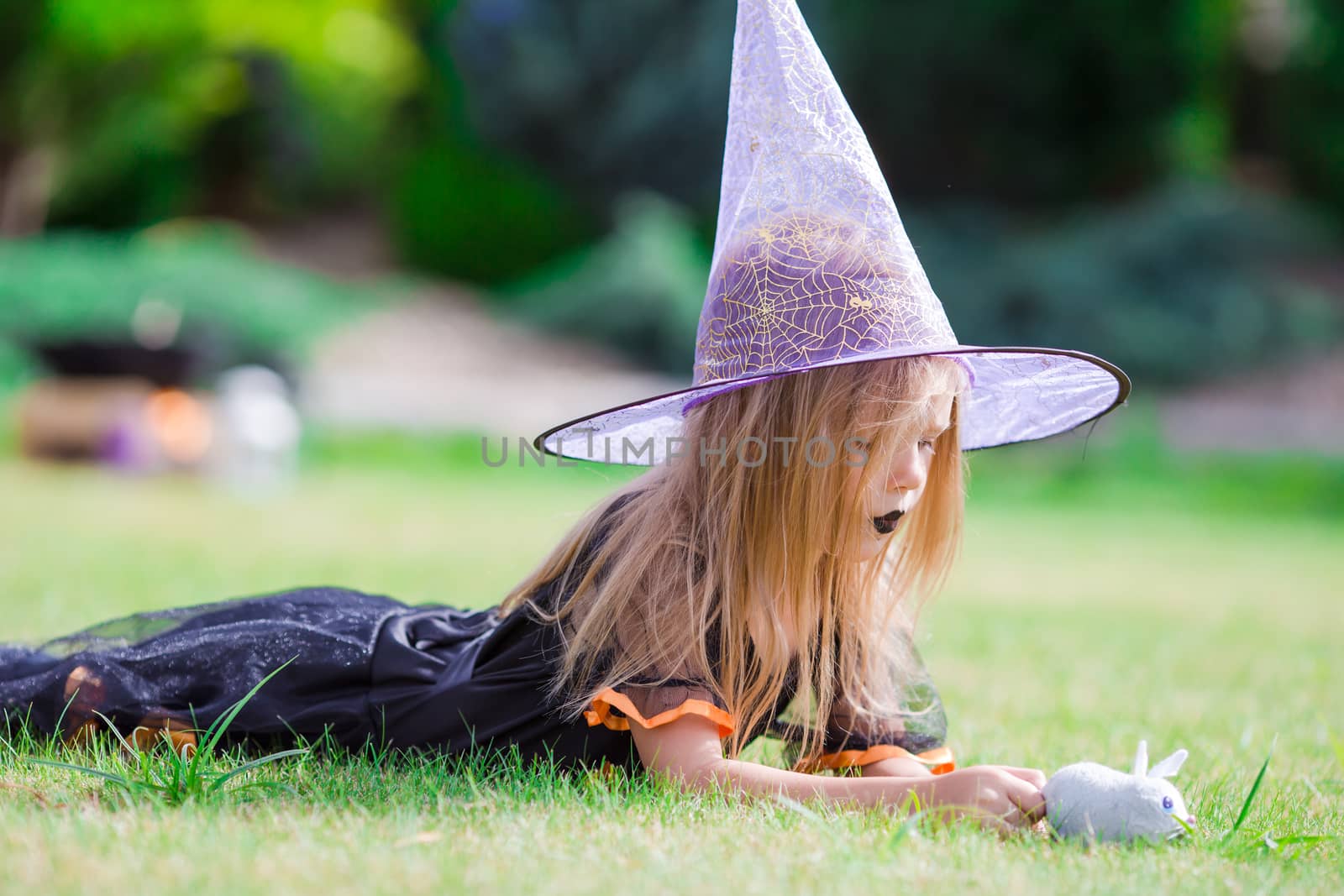 Adorable little girl wearing witch costume on Halloween at autumn day. Trick or treat. by travnikovstudio