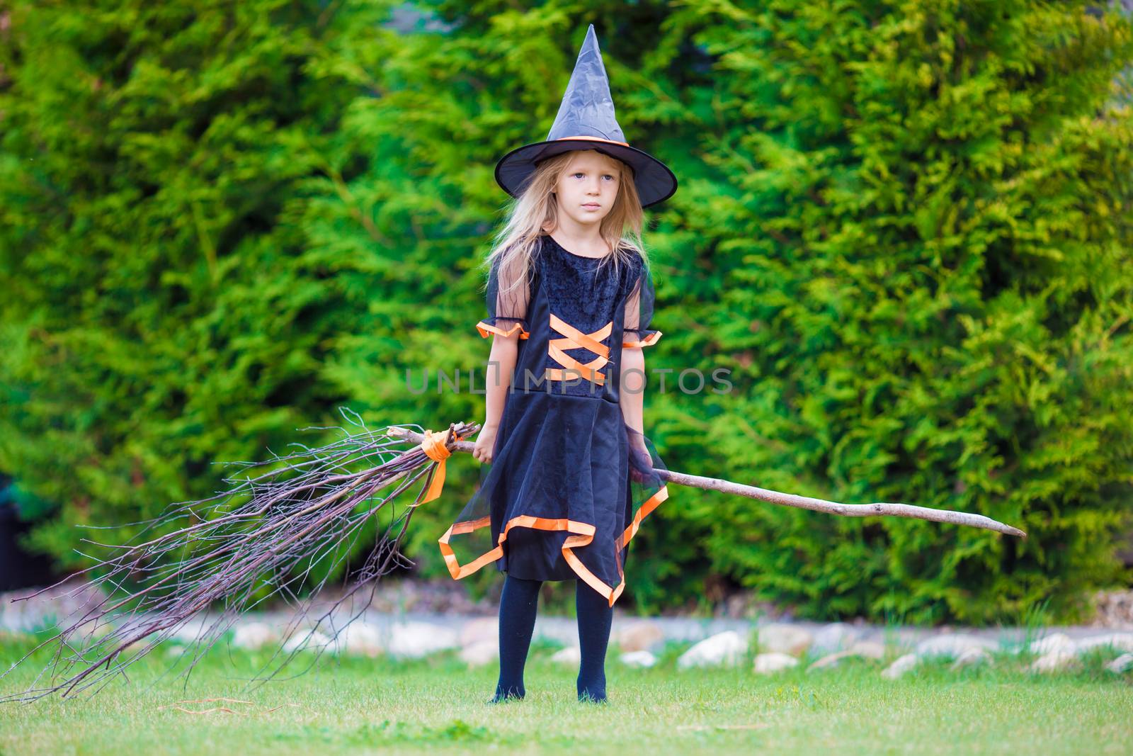 Adorable little girl in witch costume on Halloween at autumn day. Trick or treat. by travnikovstudio