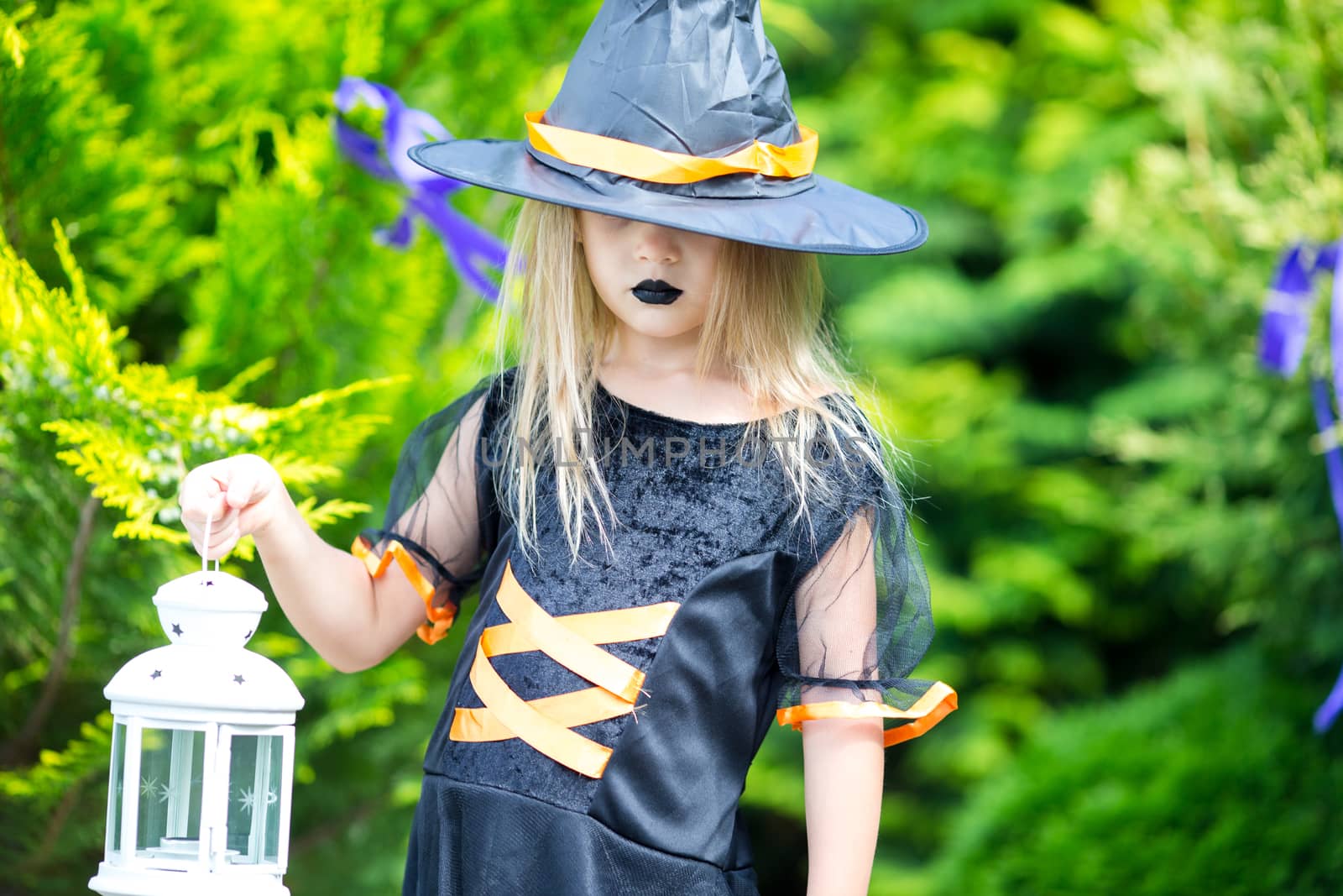 Happy little girl wearing witch costume on Halloween outdoors. Trick or treat. by travnikovstudio
