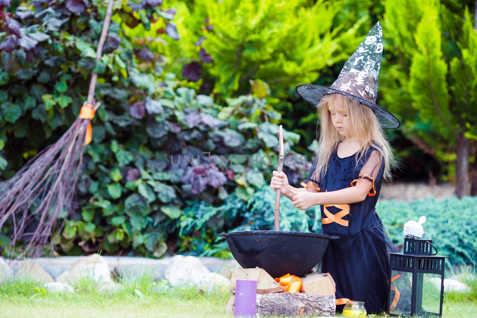 Adorable little girl wearing witch costume on Halloween at autumn day. Trick or treat. by travnikovstudio