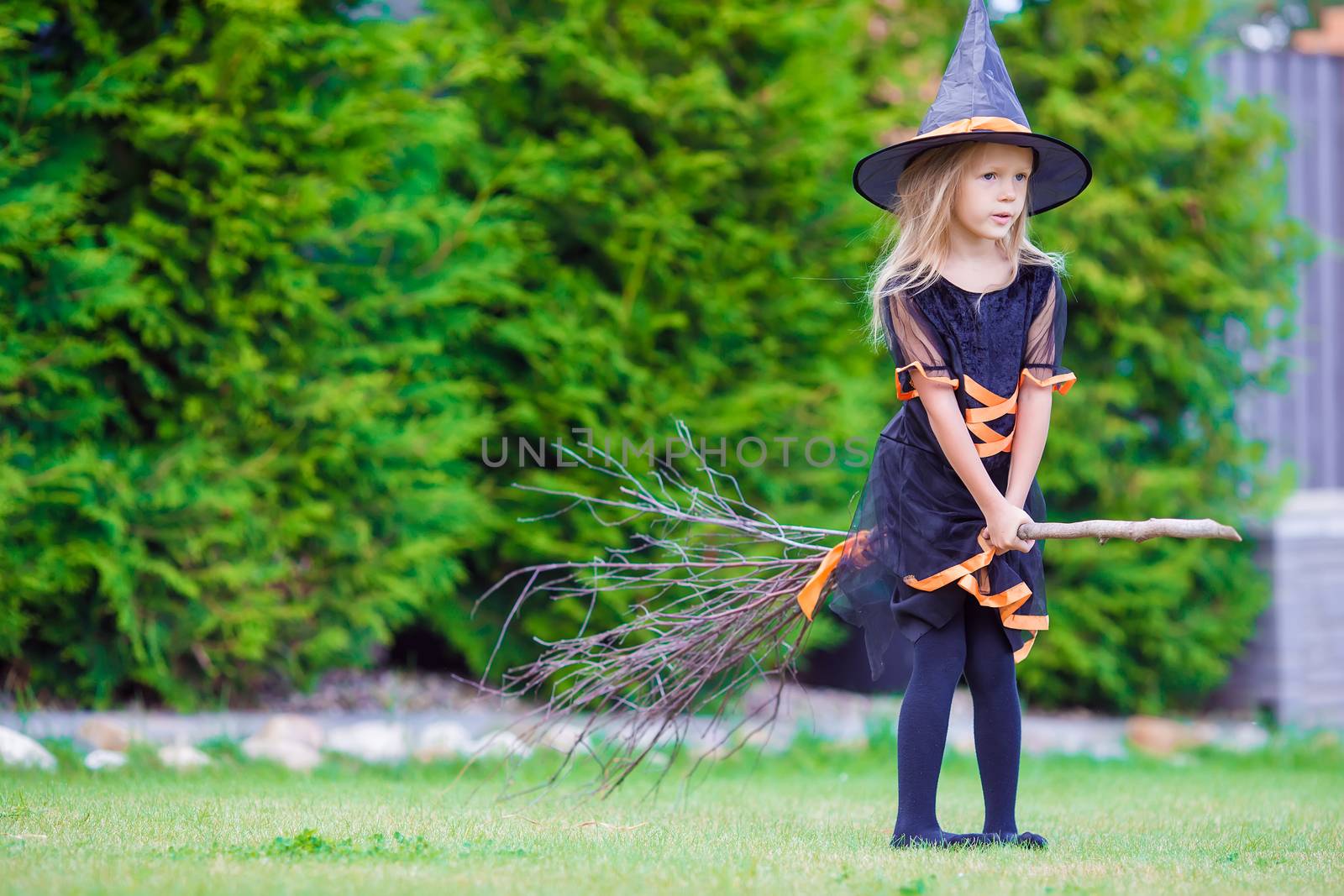 Adorable little girl wearing witch costume on Halloween at autumn day. Trick or treat. by travnikovstudio